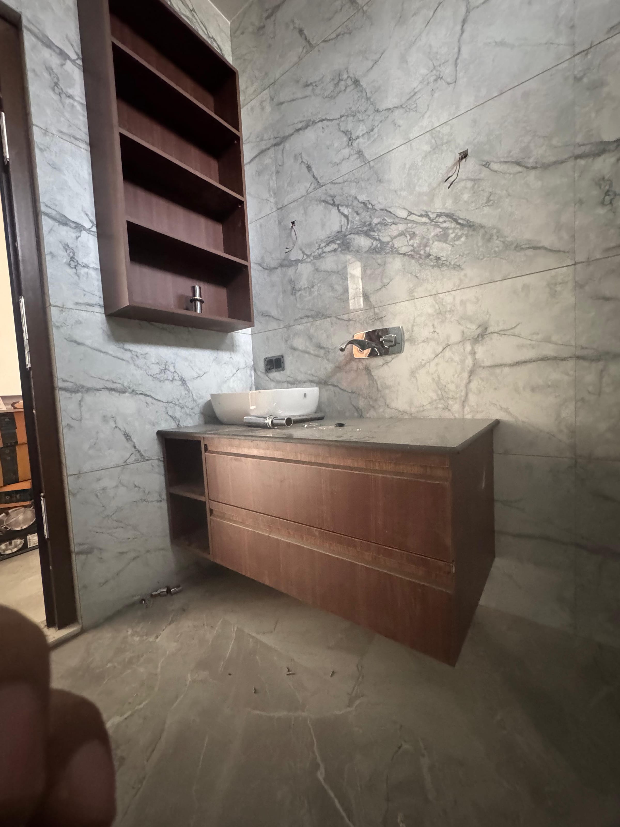 A bathroom vanity with a vessel sink and open shelving