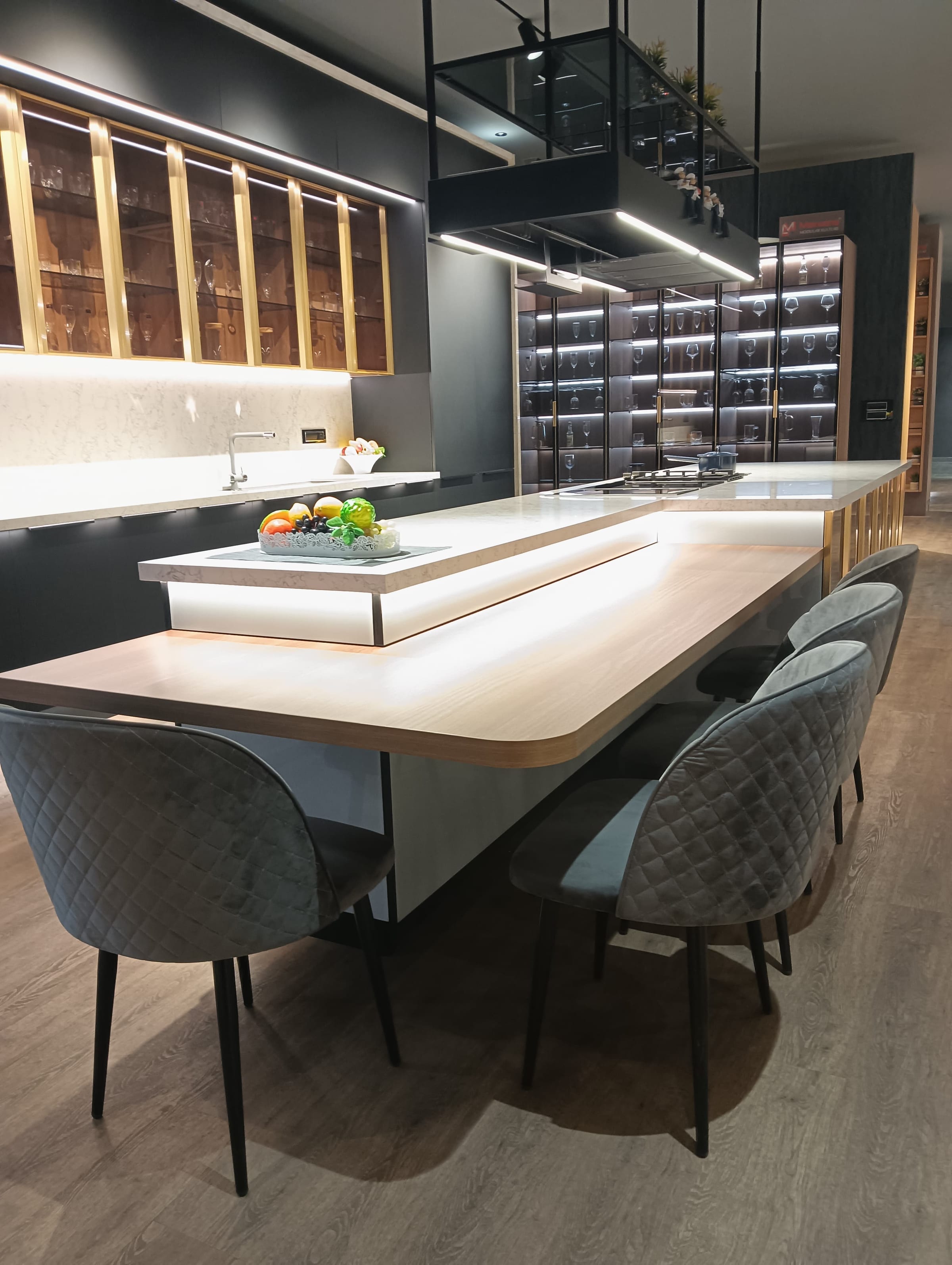 A grey kitchen island with seating along one side